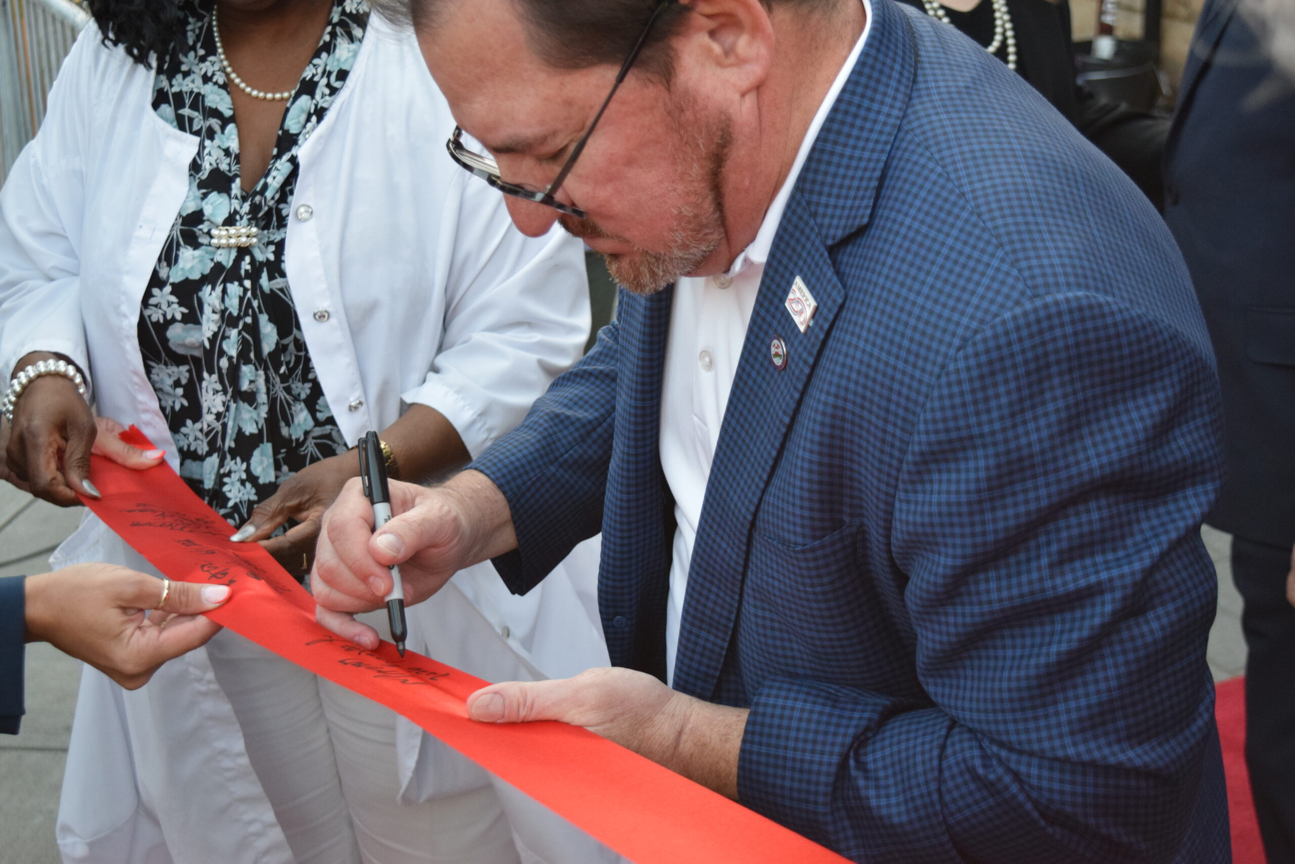 pat-perkins-auguste-manny-grova-sign-ribbon-welcome-station Councilwoman-at-Large Pat Perkins-Auguste and Council President Manny Grova sign the ribbon during the Welcome Station grand opening in Elizabeth NJ.